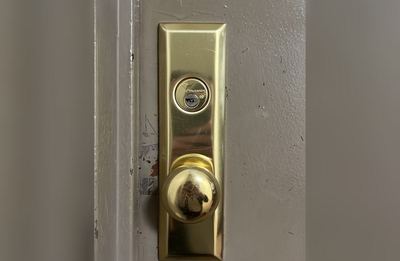 New brass front door lock installation for a Scarsdale home entry